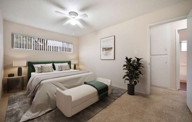 A bedroom with a large bed and a ceiling fan.