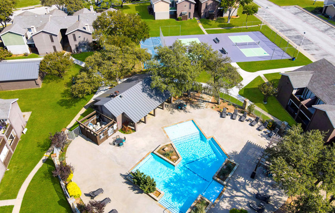 an aerial view of a yard with a swimming pool and houses