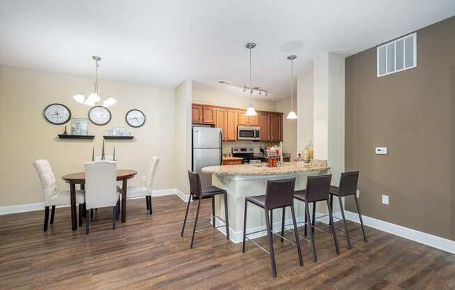 an open kitchen and dining area with a marble counter top