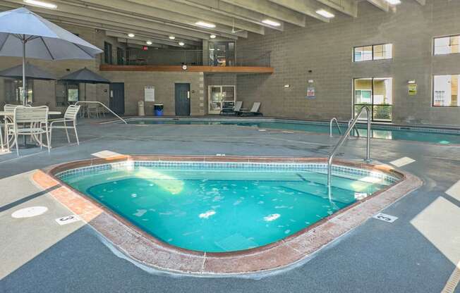 indoor spa and pool with seating and balcony