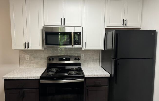 a kitchen with white cabinets and a black stove and refrigerator