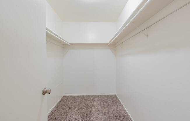 a empty room with white walls and carpet and a door