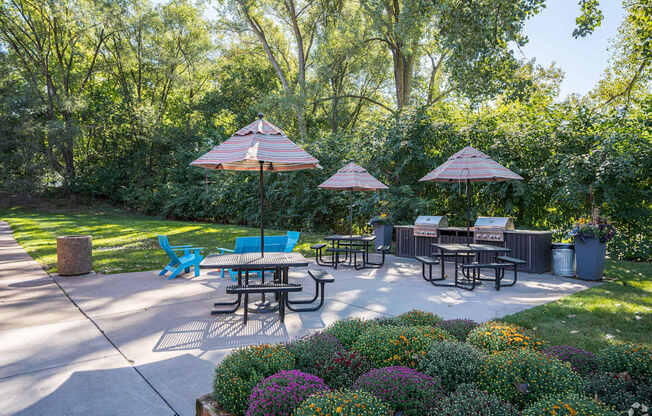 a patio with tables and umbrellas in a garden