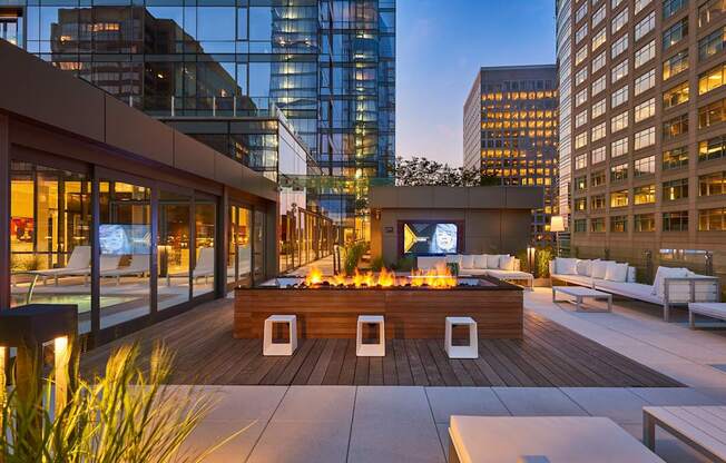 A rooftop patio with a fire pit and seating area.