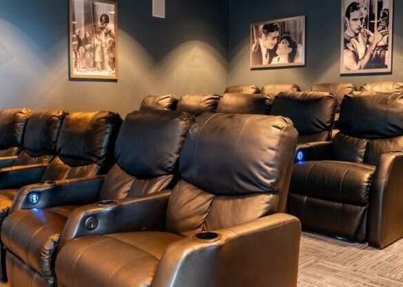 a home theater room with leather chairs and blue walls