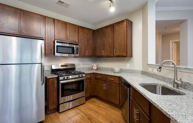 A kitchen with wooden cabinets and a stainless steel refrigerator.