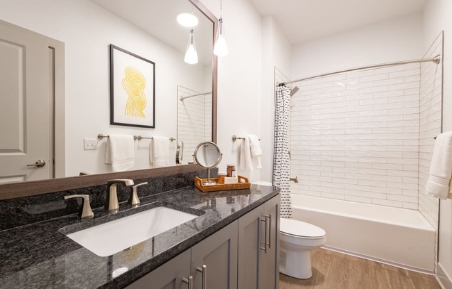 a bathroom with a gray vanity and a white bathtub