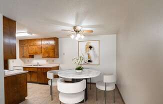 a kitchen and dining room with a table and chairs and a ceiling fan. Fargo, ND Hawn Apartments