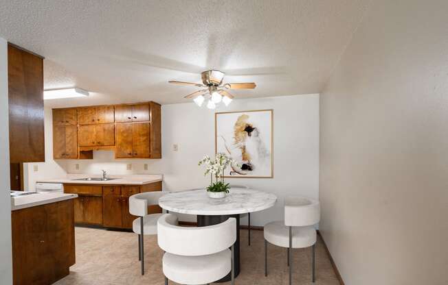 a kitchen and dining room with a table and chairs and a ceiling fan. Fargo, ND Hawn Apartments