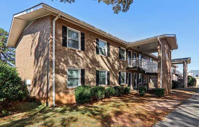A two-story brick apartment building with a balcony on the second floor.