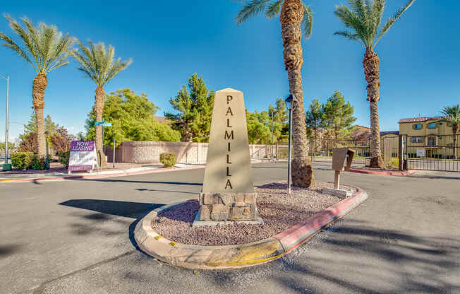 a monument in the middle of a street with palm trees