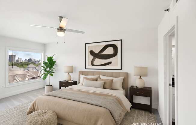 A bedroom with a large bed, a ceiling fan, and a large abstract painting above the bed.