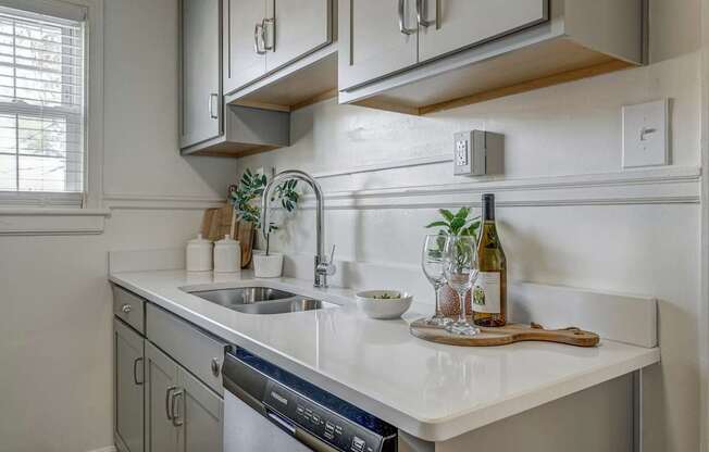 A kitchen with a white countertop and a stainless steel dishwasher.