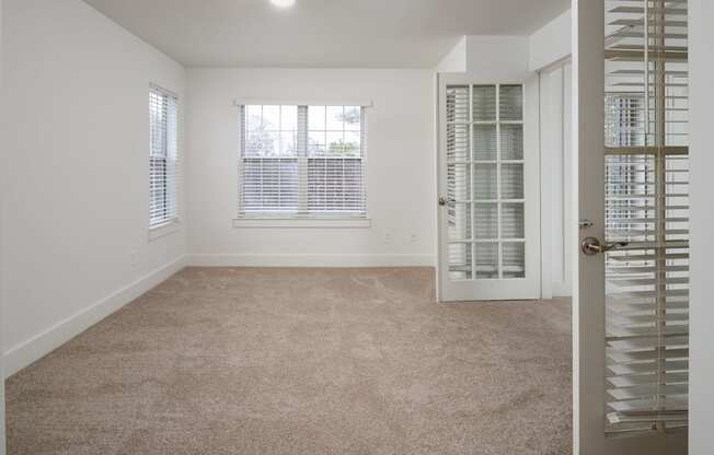A room with a carpeted floor and a door with a window.