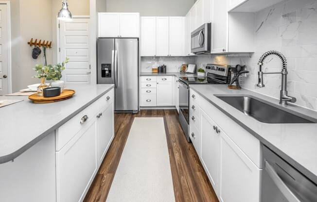 a large kitchen with white cabinets and stainless steel appliances at The Overlook, Winter Garden, FL, 34787