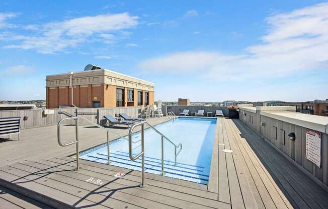 A pool on a rooftop with a building in the background.