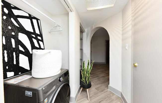 A laundry basket sits on a washing machine in a small room.