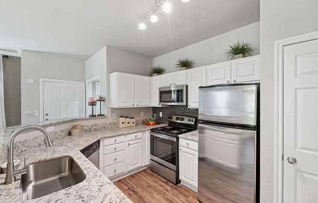 A kitchen with white cabinets and stainless steel appliances.