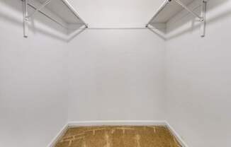 an empty room with white walls and a brown carpet