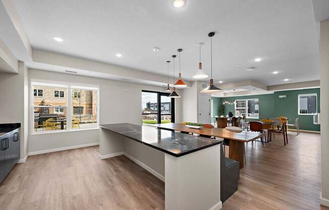 A modern kitchen with a large island and pendant lights.