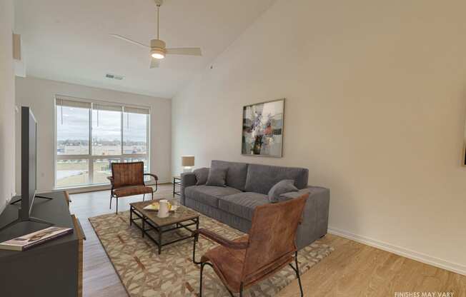a living room with a gray couch and two brown chairs