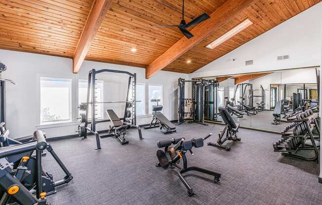 A gym with a variety of equipment including weights and machines.