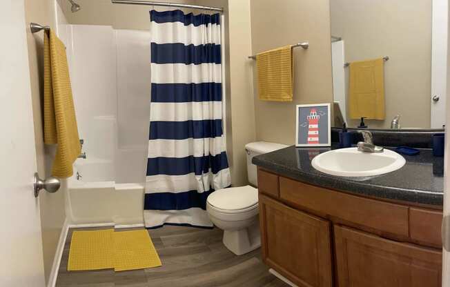 a bathroom with a sink toilet and shower and a shower curtain