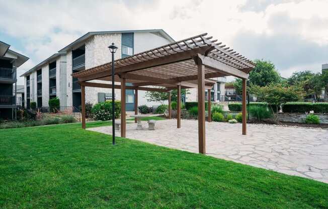 a patio with a pergola in front of a building