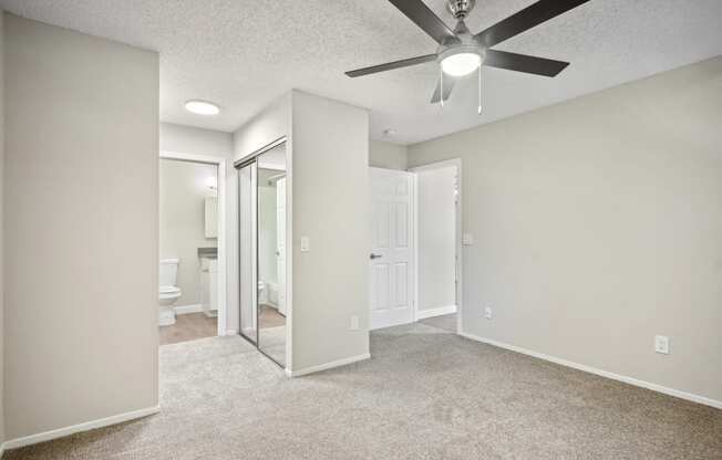 an empty living room with a ceiling fan