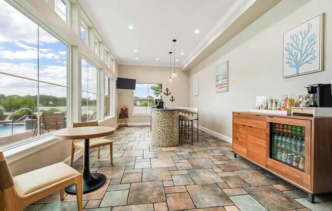 A kitchen with a table and chairs and a fridge.