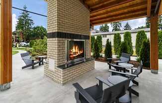 A modern outdoor patio with a fireplace and seating area.