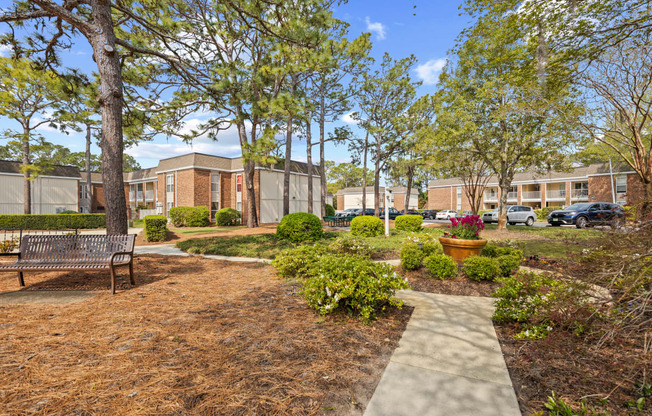 a park with a bench and trees in front of a building