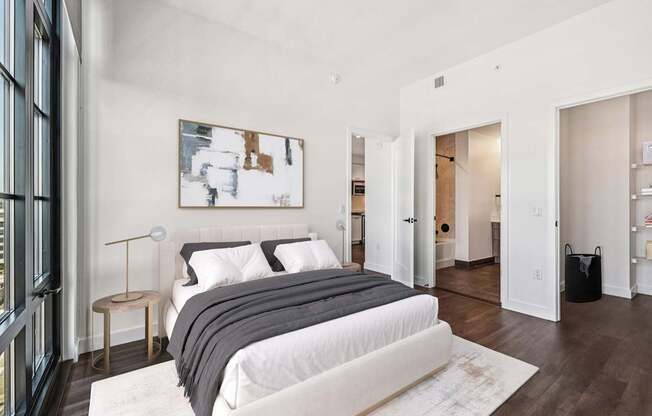 A bedroom with a large bed and a painting on the wall.