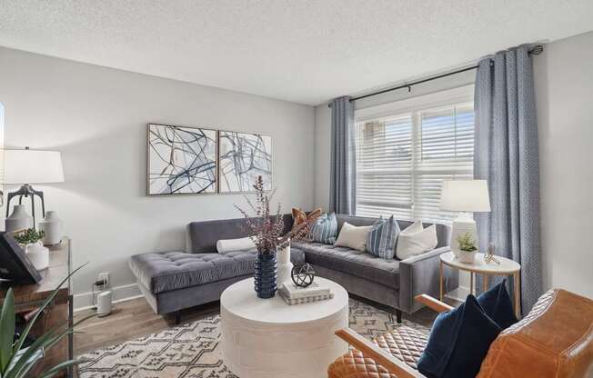 Open-concept living room with natural light and wood-style flooring in a Hendersonville apartment