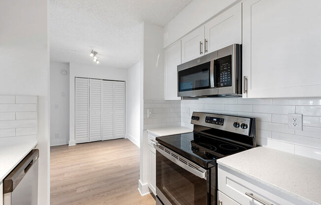 A kitchen with a black stove top oven and white cabinets.