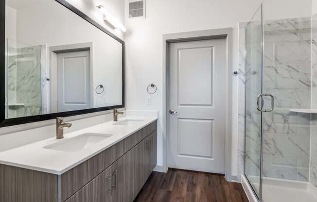 A bathroom with a white sink and a mirror above it.