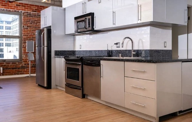 a kitchen with white cabinets and a stainless steel refrigerator