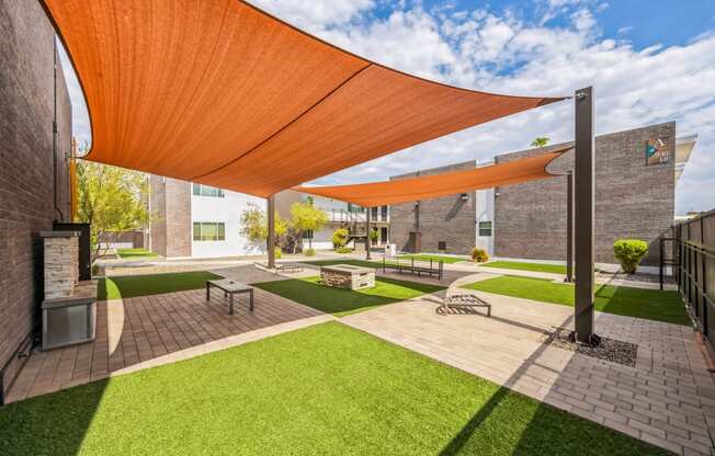 a courtyard with awnings and benches and grass