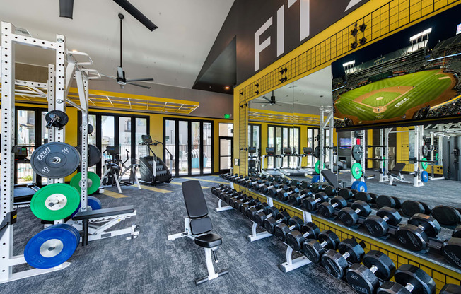 a gym with weights and a football scoreboard on the wall