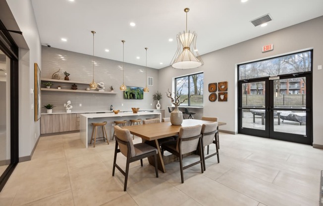 the gathering room and kitchen of a home with a dining table and chairs