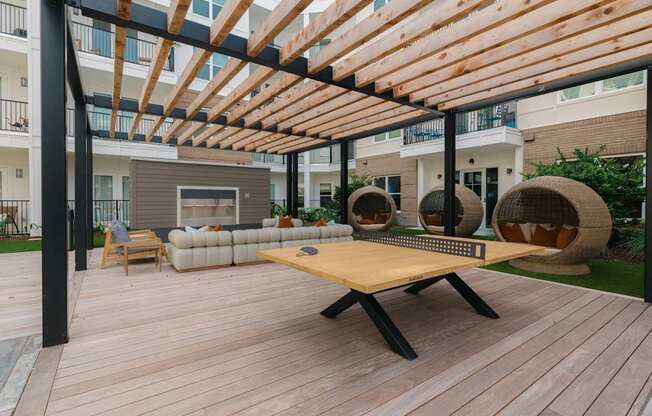 A wooden table is in the middle of a wooden deck.