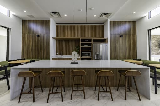 the kitchen has a large island with stools and a group of chairs