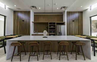 the kitchen has a large island with stools and a group of chairs