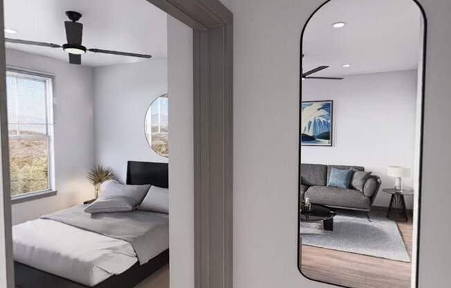 A bedroom with a bed, a ceiling fan, and a mirrored wall at Refinery at Pointe17 Apartments, Arizona