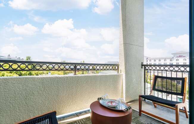 a balcony with a table and chairs and a view of the ocean