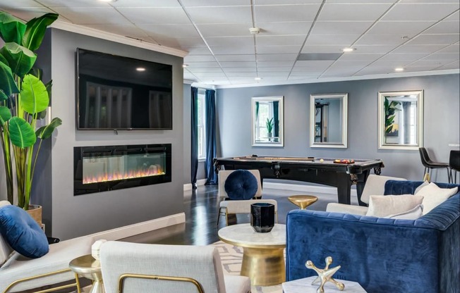 a living room with couches and a pool table and a fireplace