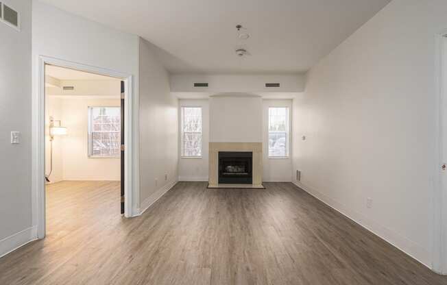 the living room and dining room of an empty house with a fireplace