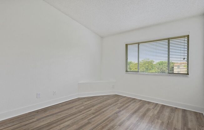Bedroom with vinyl flooring and large window