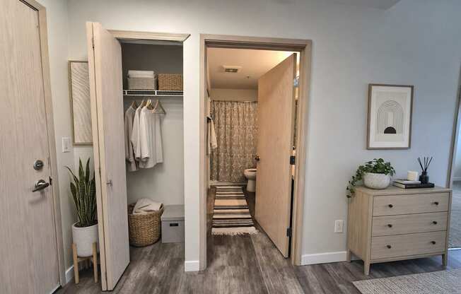 A room with a wooden floor and a white wall with a picture hanging on it.