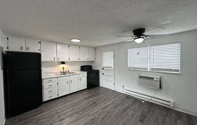 a kitchen with white cabinets and black appliances